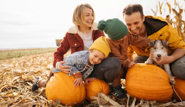 Family laughing in a pumpkin patch