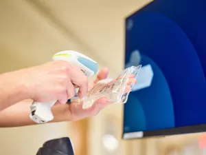 Closeup of a Lowell General Hospital nurse scanning medication at a computer workstation.