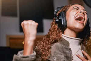 Female singer singing passionately into studio microphone.