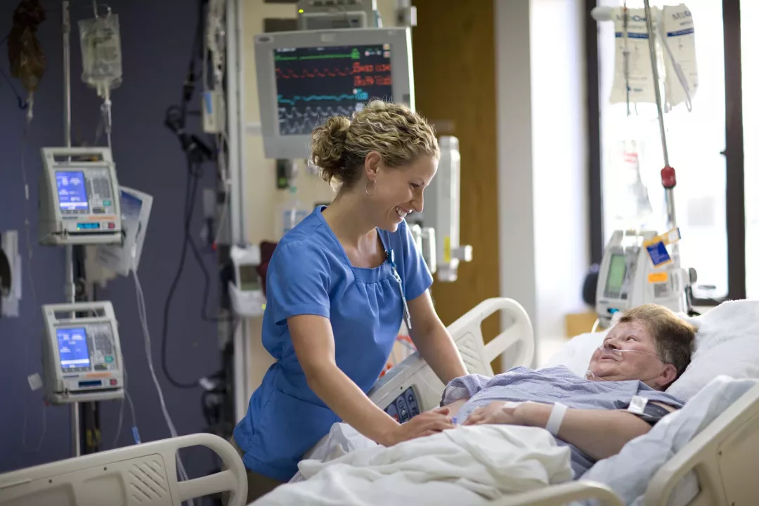 Katie Miller, RN comforts patient in the SICU at Tufts Medical Center.
